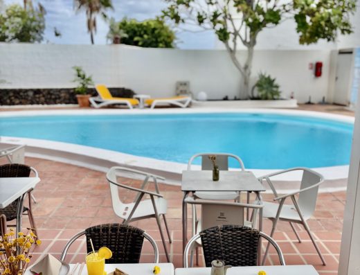 Terraza junto a la piscina y las palmeras de Tamarindos Bistró