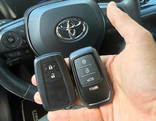 Llave de mando de un Toyota y su duplicado, junto al volante