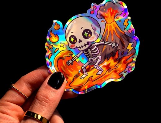 Pegatina holográfica troquelada con un esqueleto surfeando la lava de un volcán, de Vulcan Sticker
